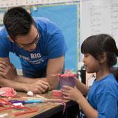 an image of a teacher working closely with a young student